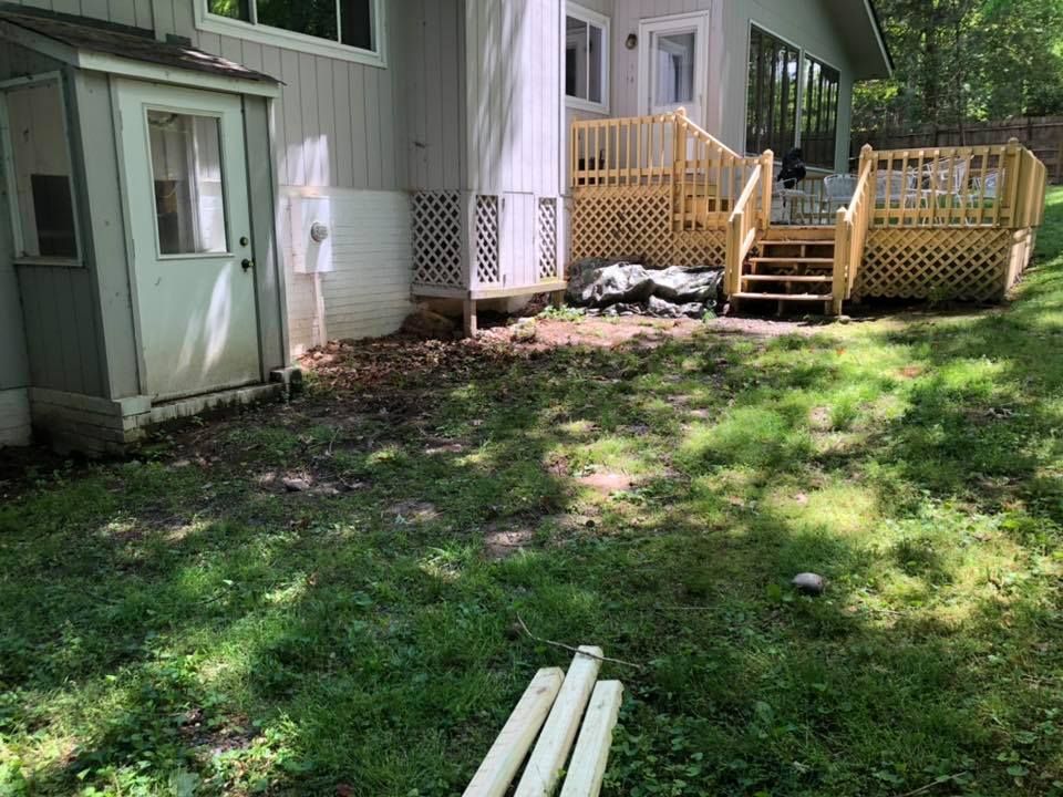 A house with a deck and a shed in the backyard.