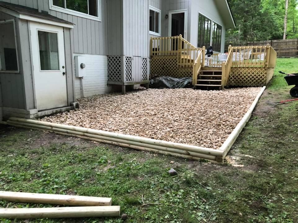 A wooden deck is being built in front of a house.