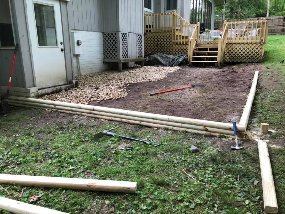 A wooden deck is being built in the backyard of a house.