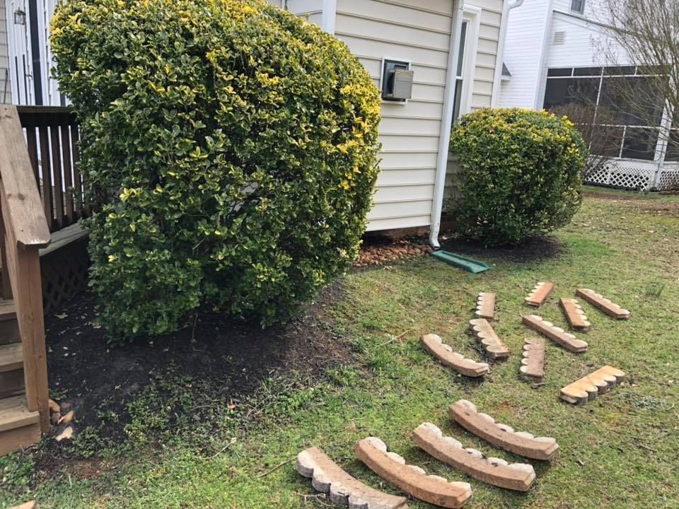 A bunch of wooden blocks are laying on the grass in front of a house.
