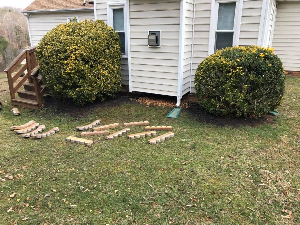 A house with a lot of bushes in front of it.