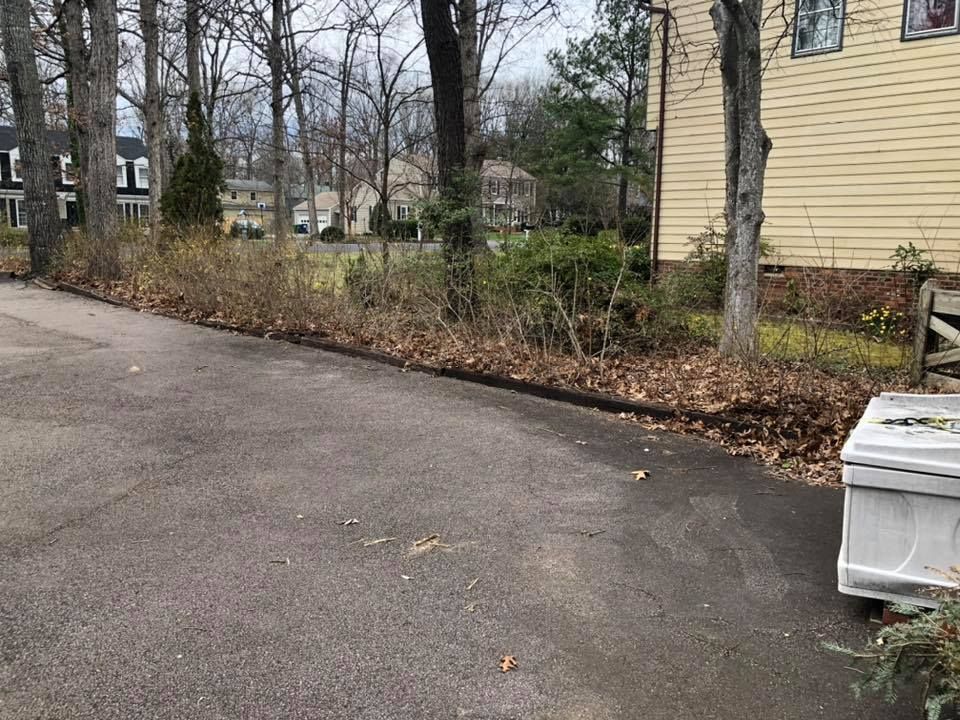 A white box is sitting on the side of a road next to a house.