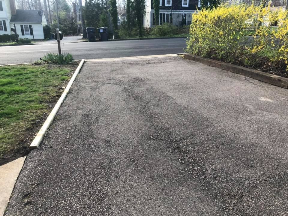 A car is parked in a driveway next to a house.