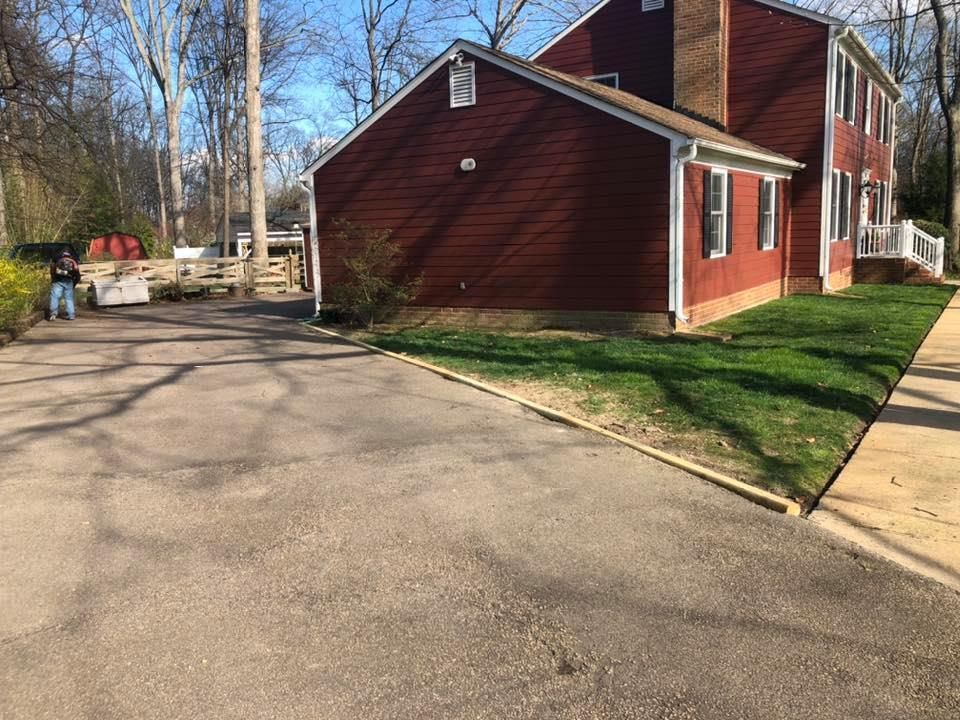 A man is standing in front of a red house.