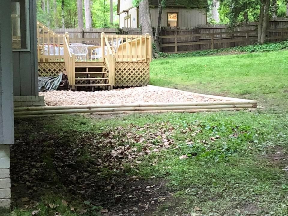 A backyard with a wooden deck and a fence