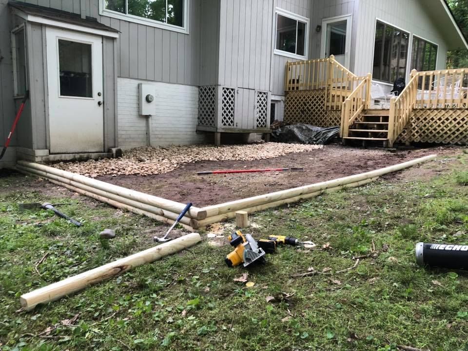 A wooden deck is being built in front of a house.