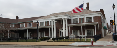 A large brick building with an american flag on top of it