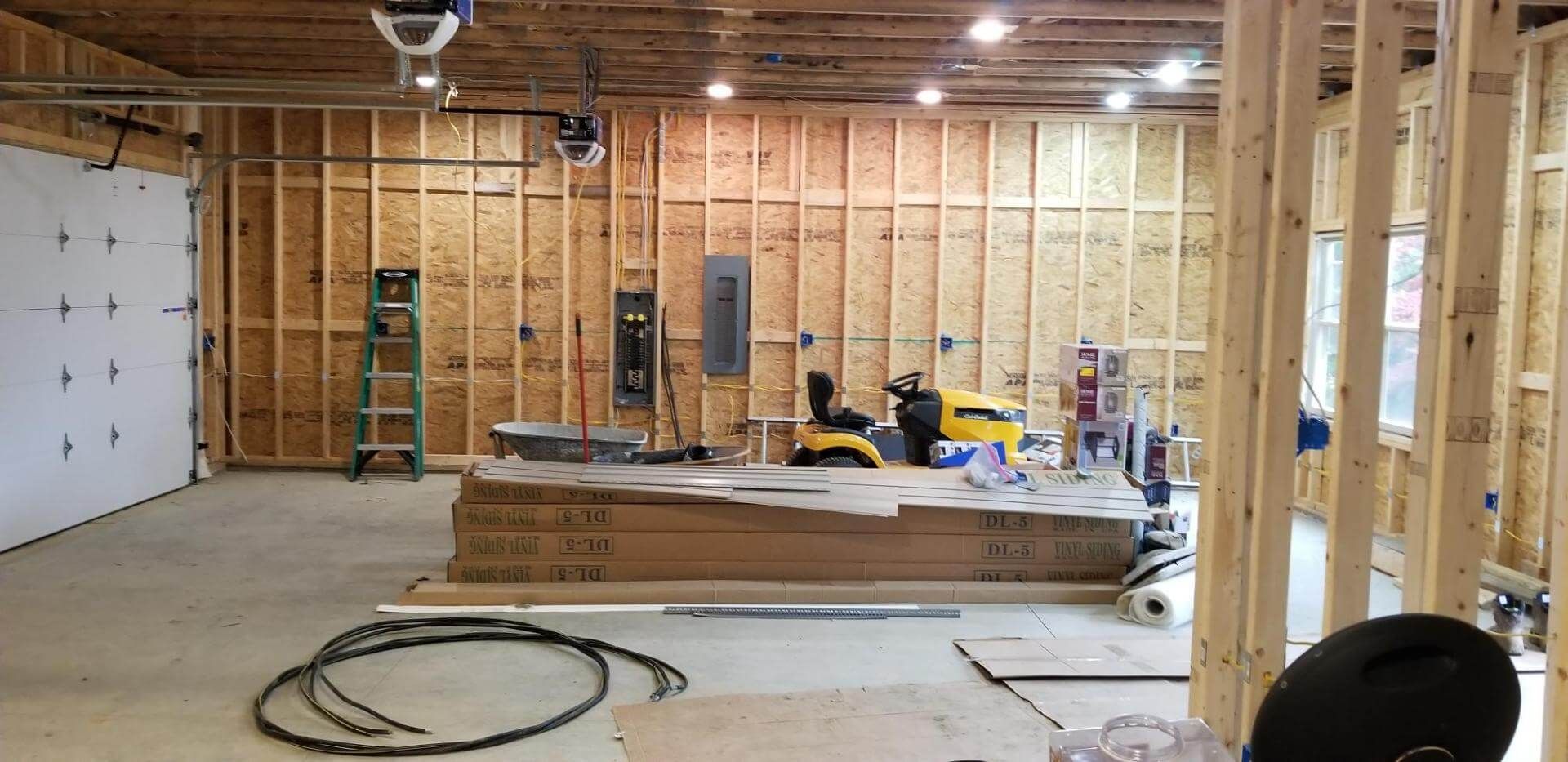 Interior of a garage under construction with wood framing, tools, and supplies.