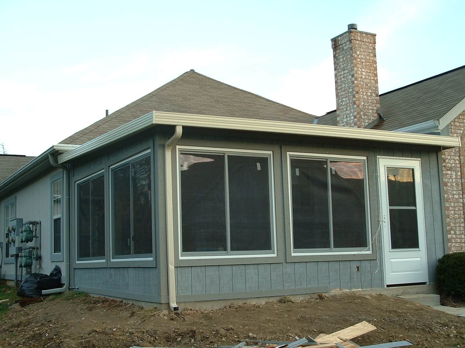 Roofers installing asphalt shingles on a residential roof; tools and materials visible.