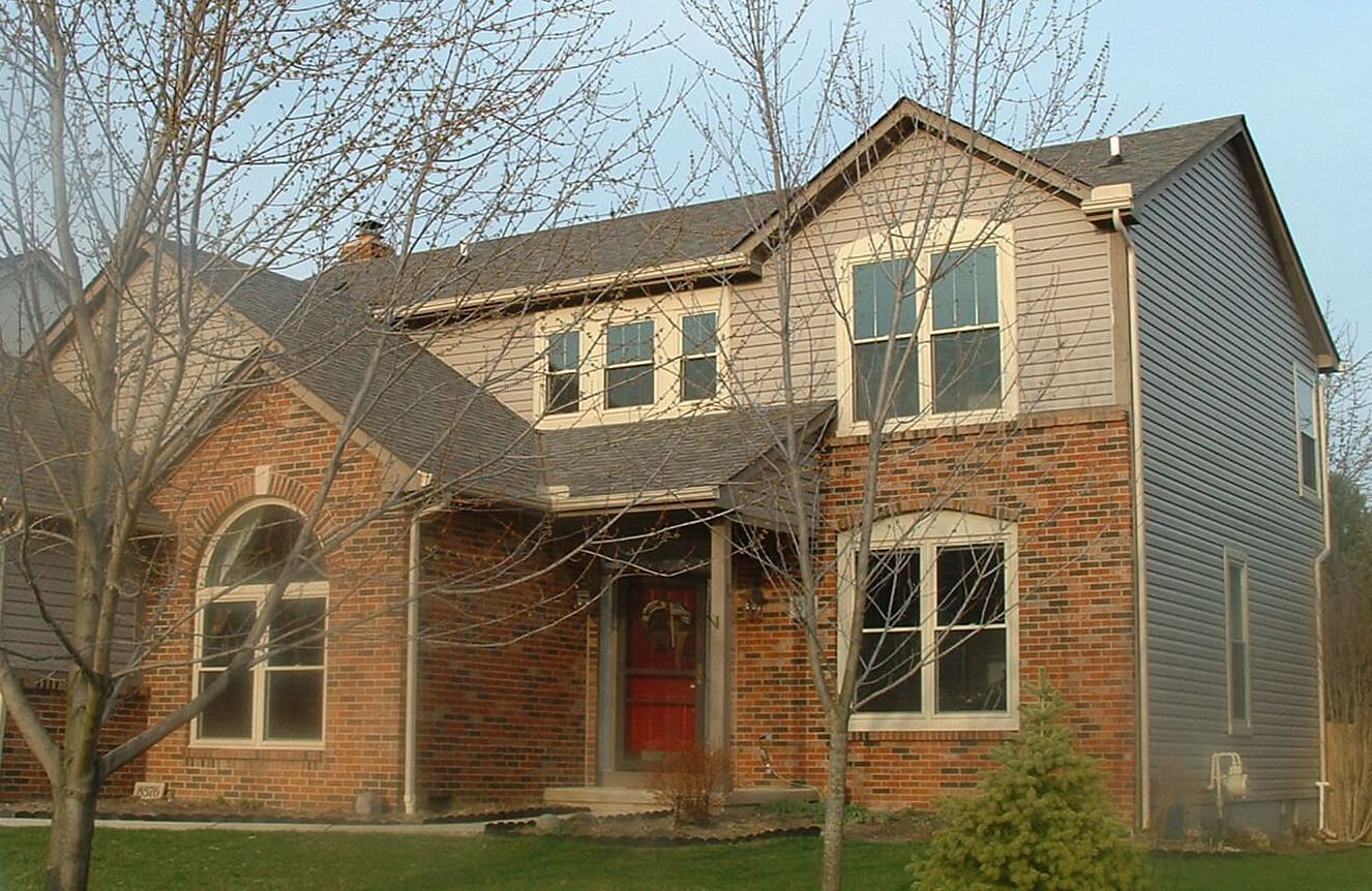 Roofers installing asphalt shingles on a residential roof; tools and materials visible.