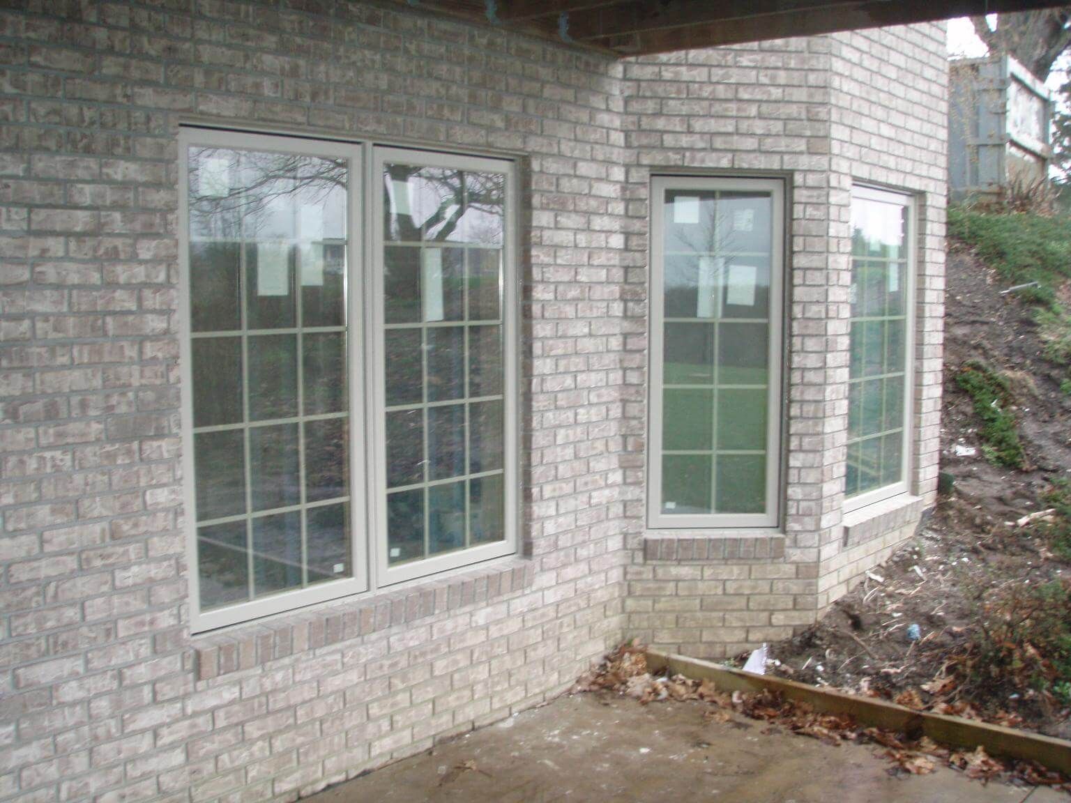 Roofers installing asphalt shingles on a residential roof; tools and materials visible.