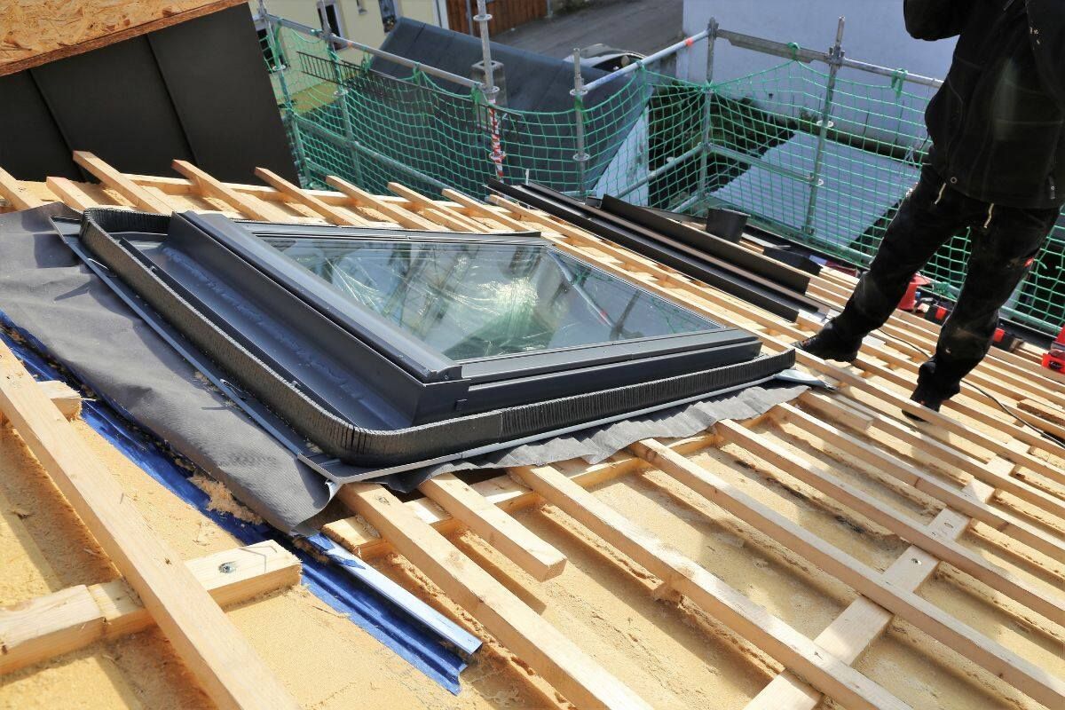 Roofers installing asphalt shingles on a residential roof; tools and materials visible.