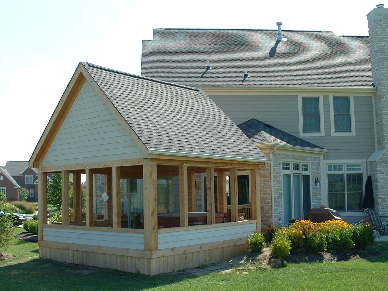 Roofers installing asphalt shingles on a residential roof; tools and materials visible.