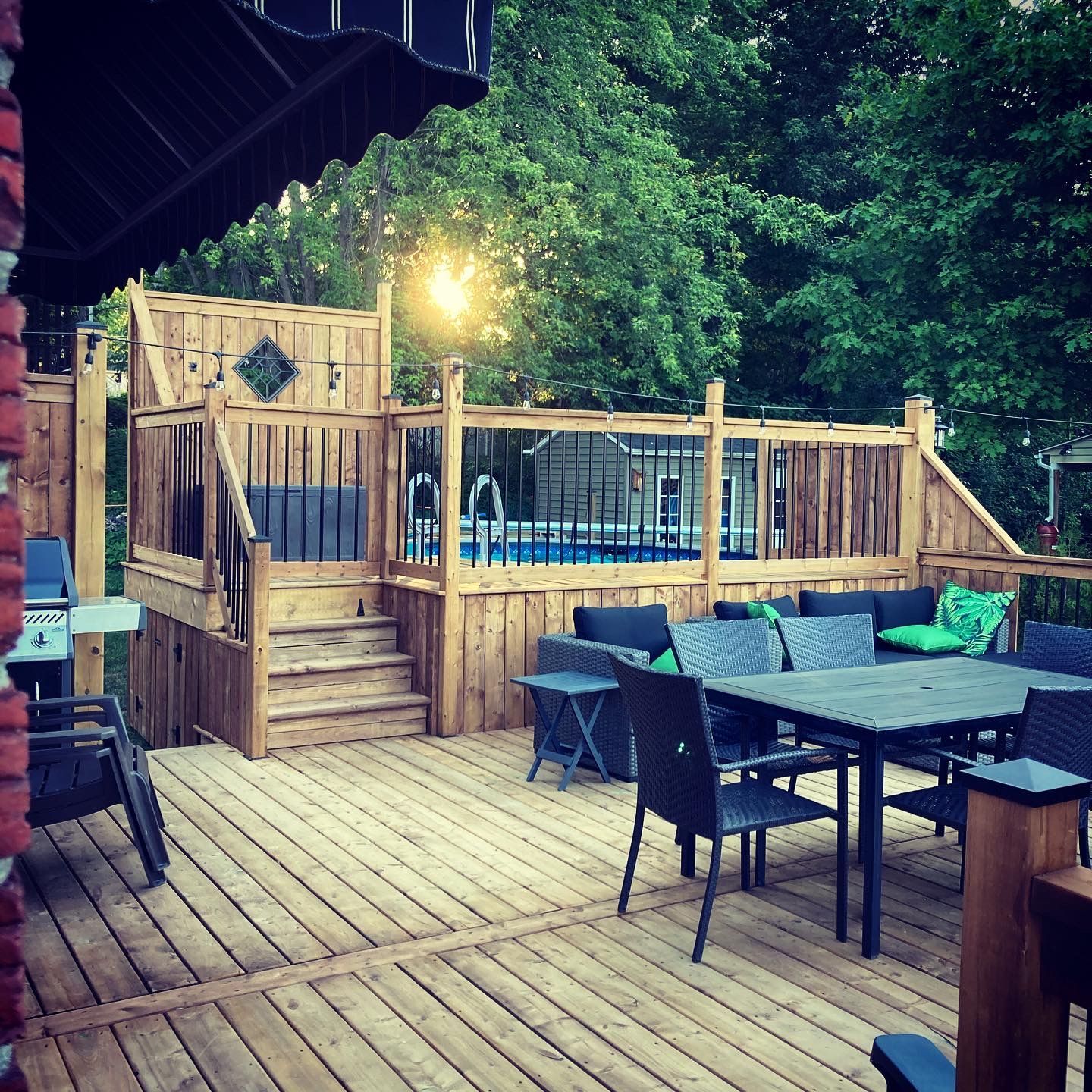 Une terrasse en bois avec une table et des chaises et une piscine en arrière-plan