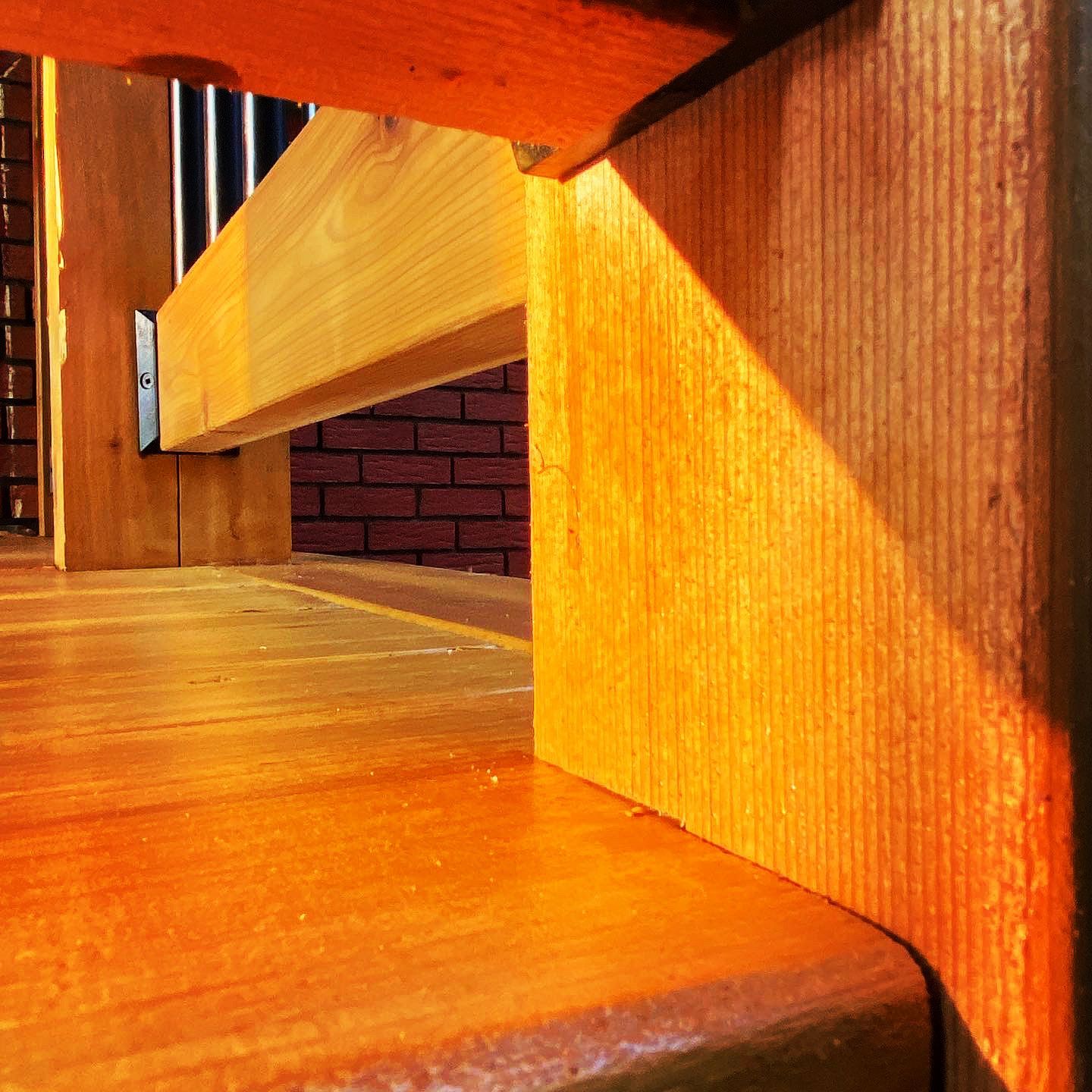 Un escalier en bois avec un mur de briques en arrière-plan