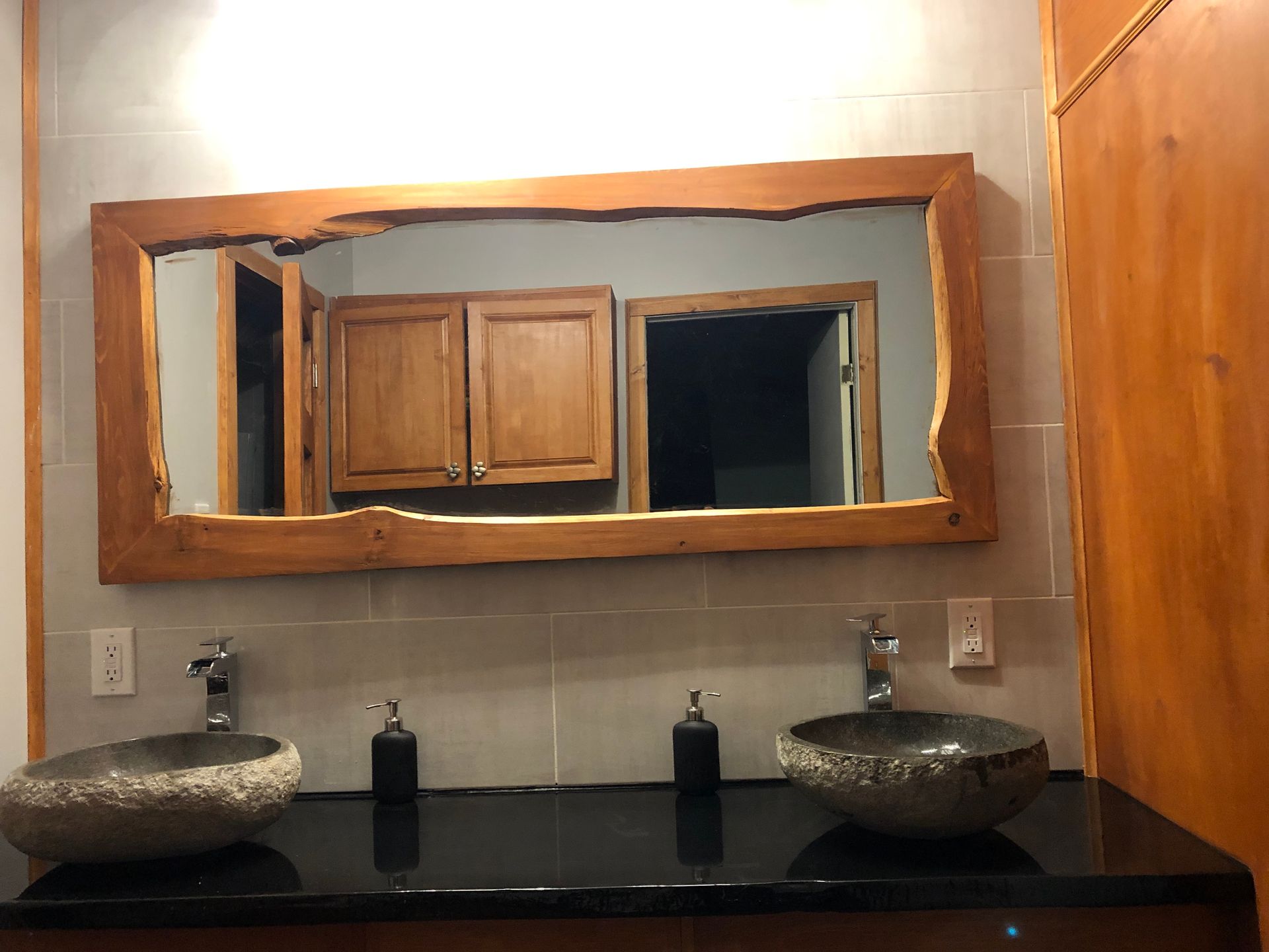 Une salle de bain avec deux lavabos et un grand miroir