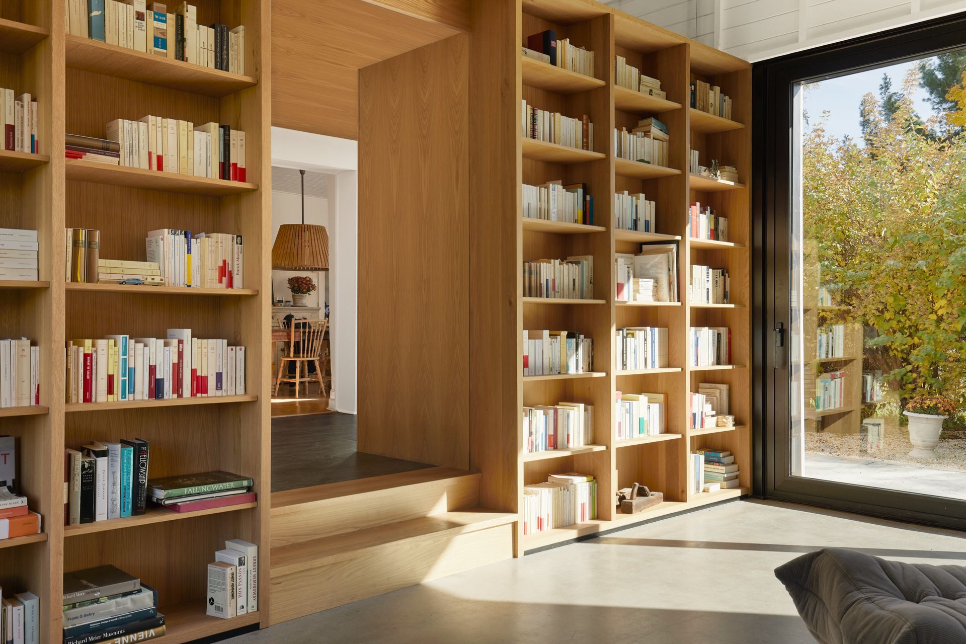 Un salon rempli d'étagères et d'une grande fenêtre