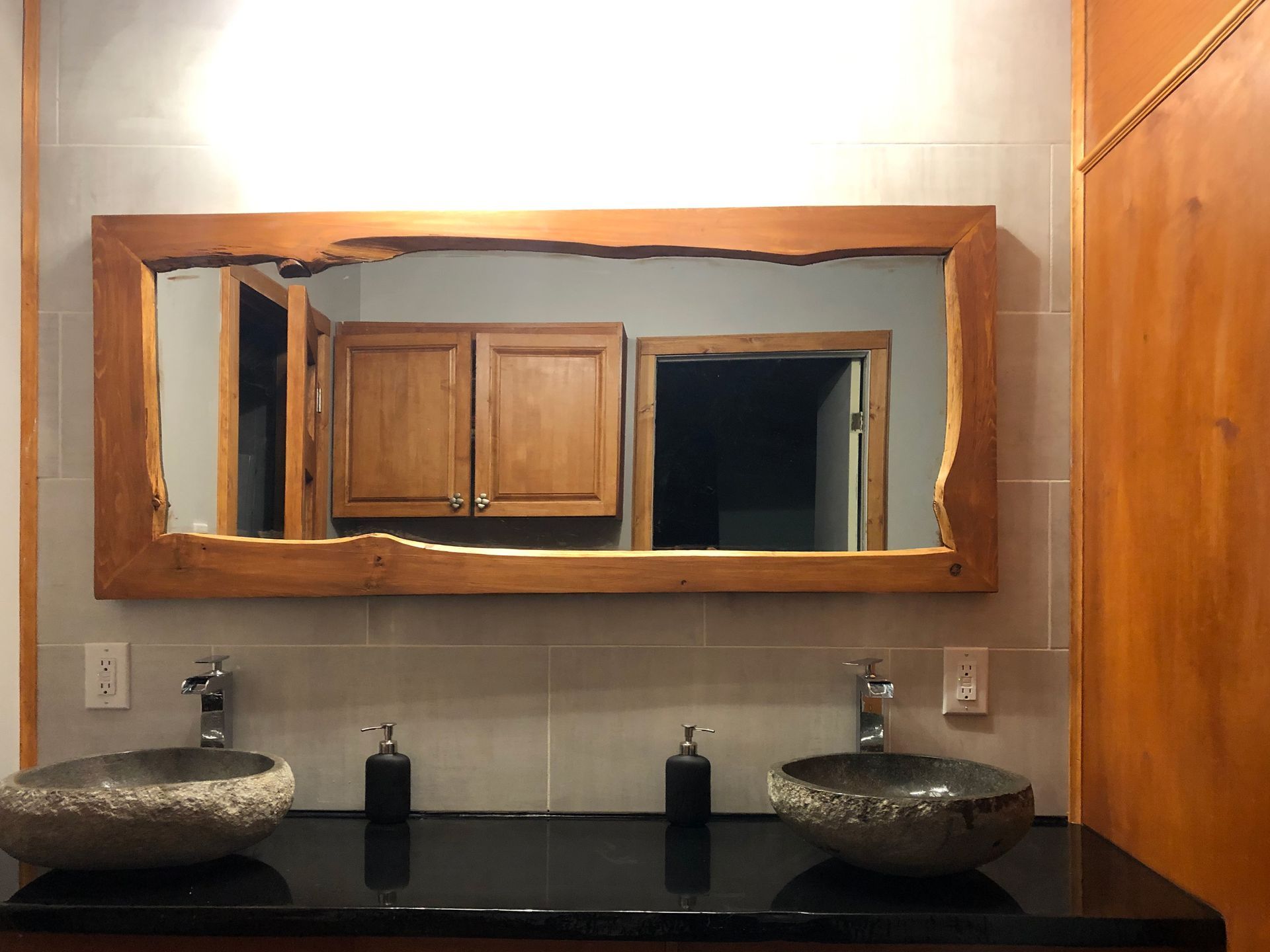 Une salle de bain avec deux lavabos et un grand miroir