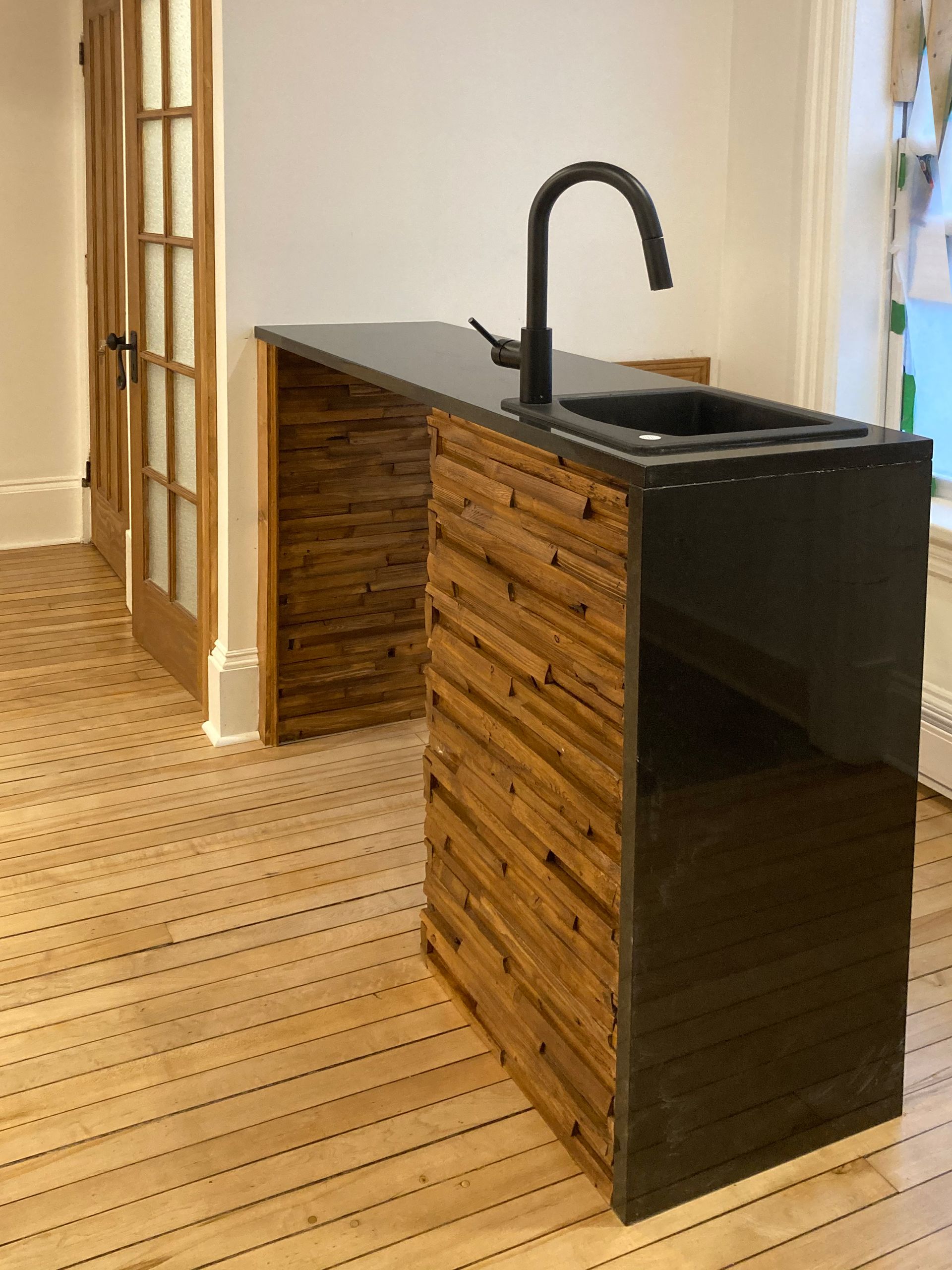 Un îlot de cuisine avec un évier et un comptoir en bois