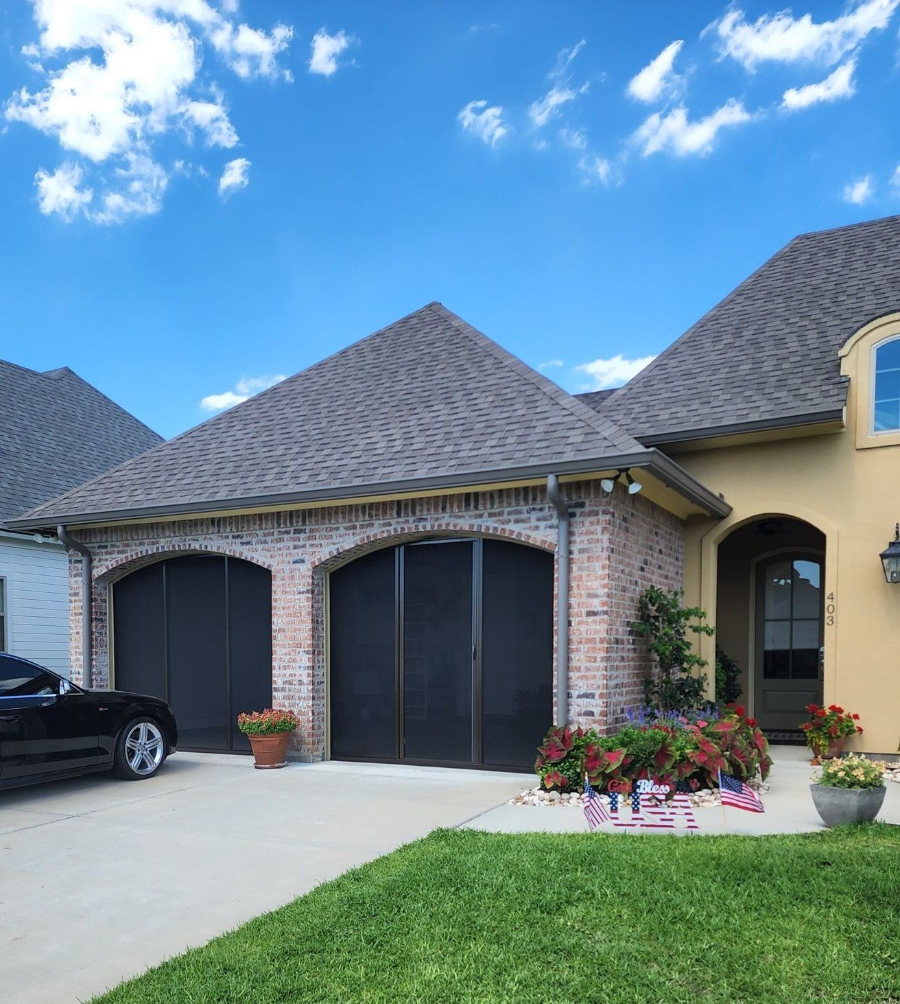a black car is parked in front of a house