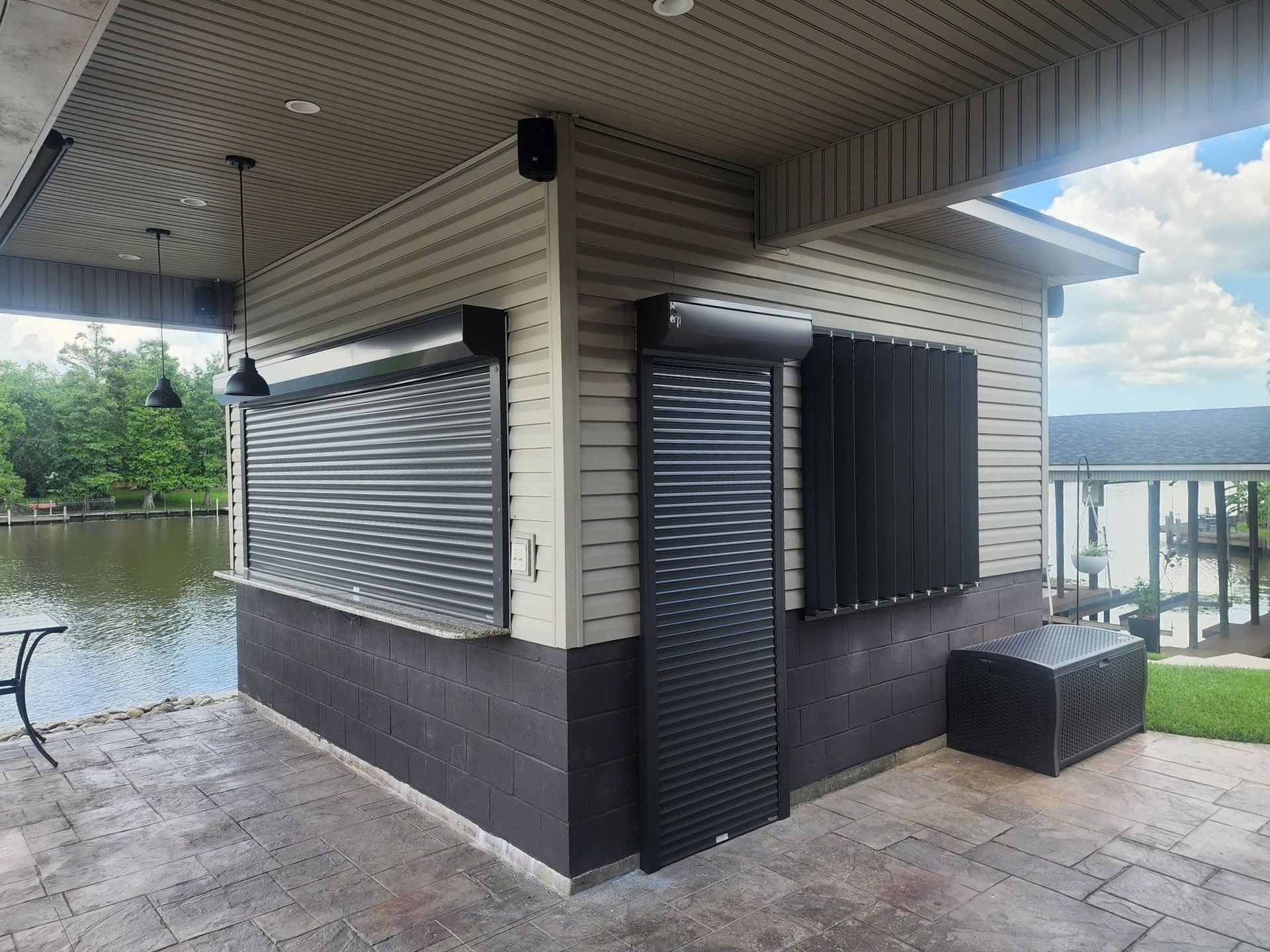 a building with shutters on the windows is next to a body of water .