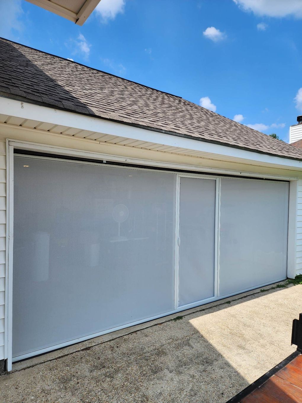 a garage door with a screen on it and a blue sky in the background .