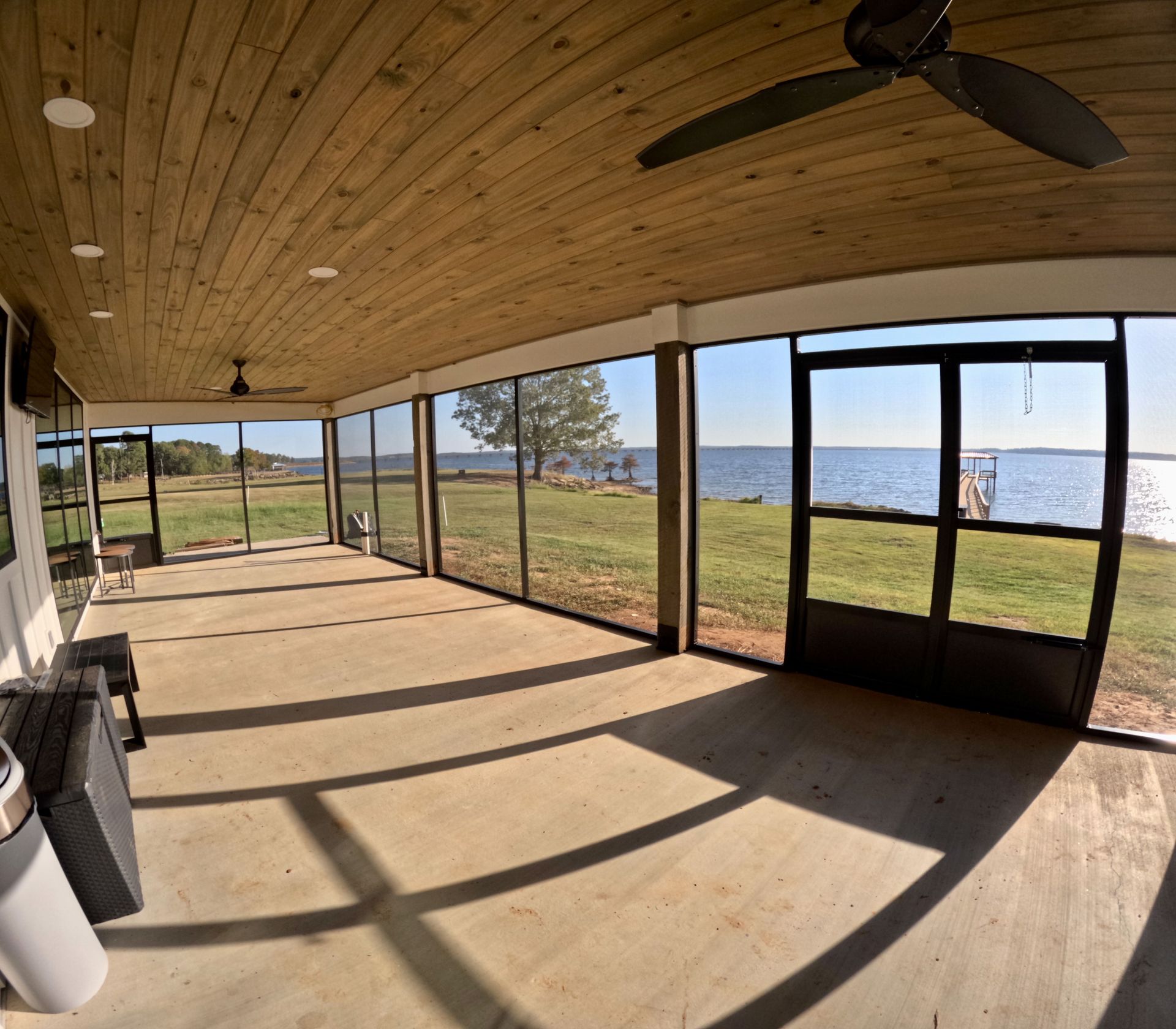 a screened in porch with a view of the water