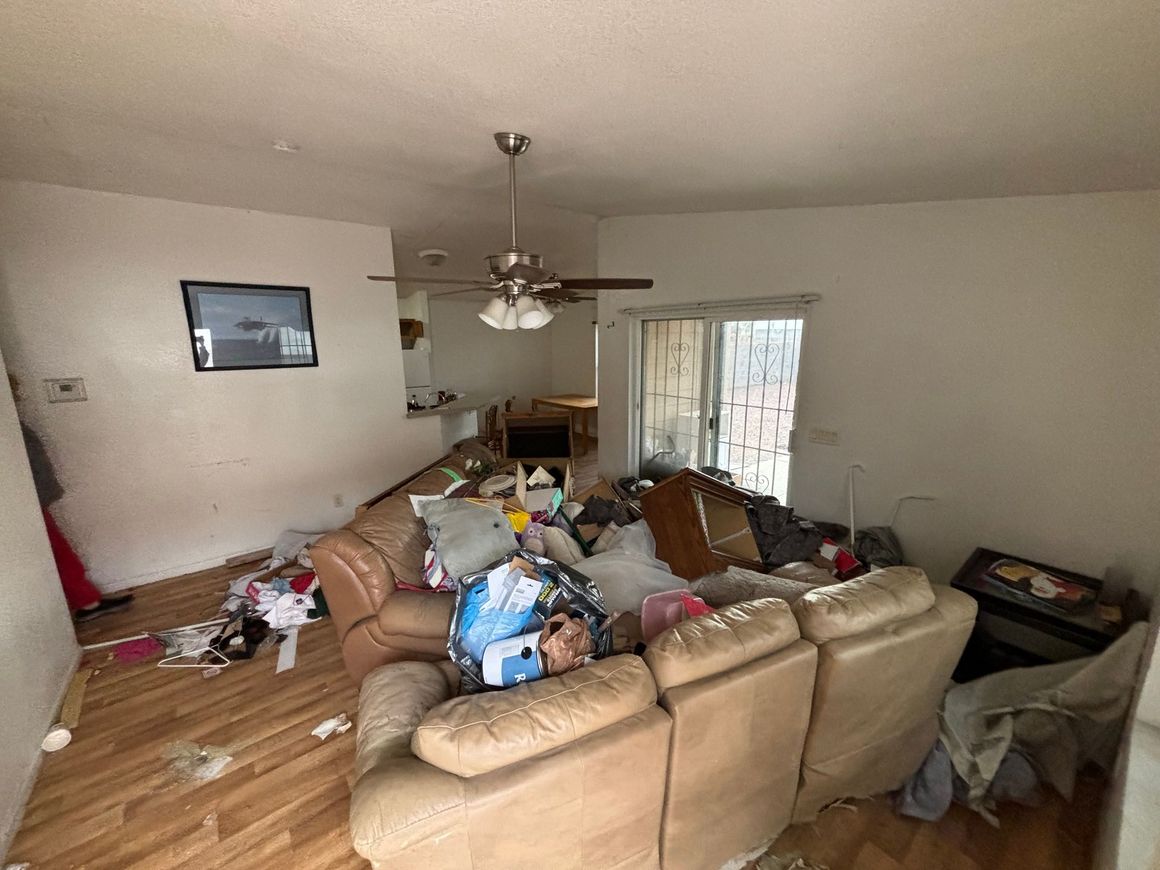 A living room filled with furniture and a ceiling fan.