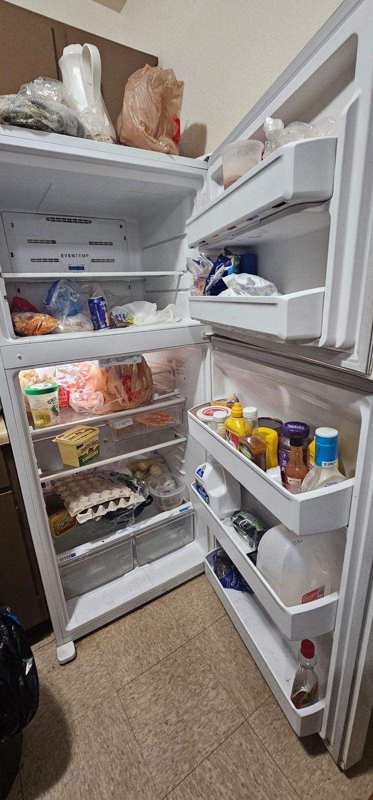 An open refrigerator filled with lots of food in a kitchen.