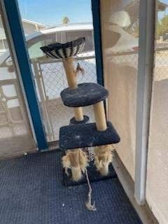 A cat tree is sitting in a room next to a window.