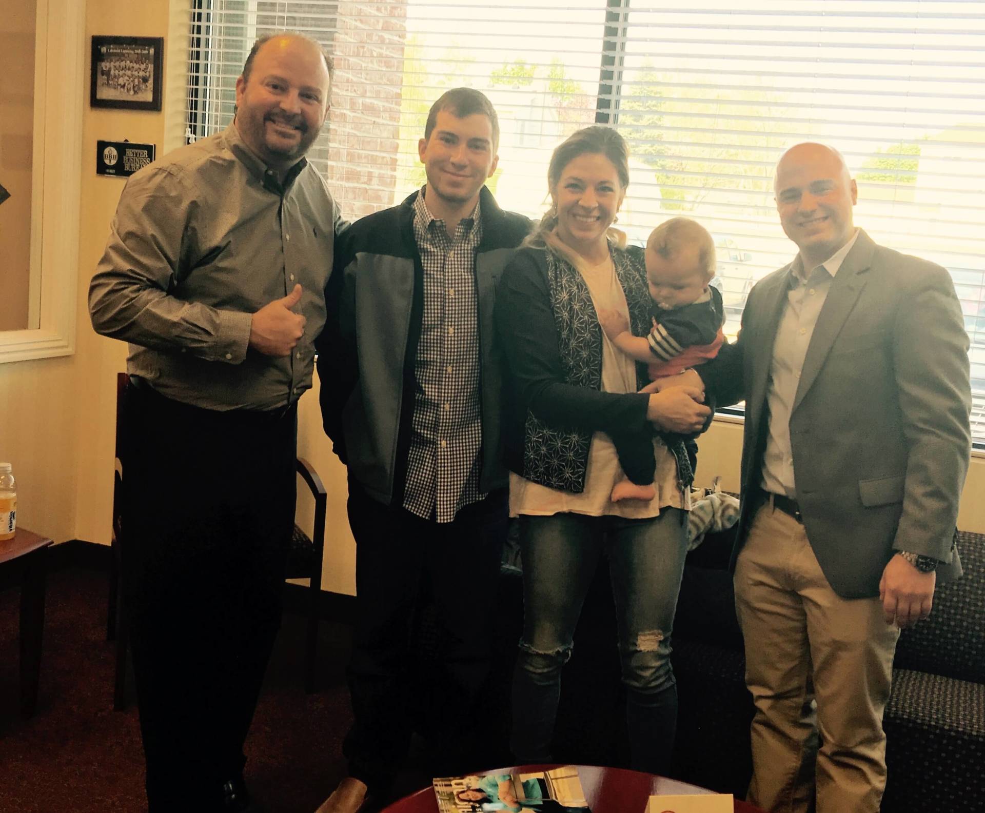 A group of people are posing for a picture in a waiting room.