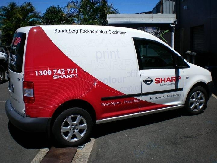 A Red and White Sharp Van Is Parked in A Parking Lot — Signmax Bundaberg In Kensington, QLD