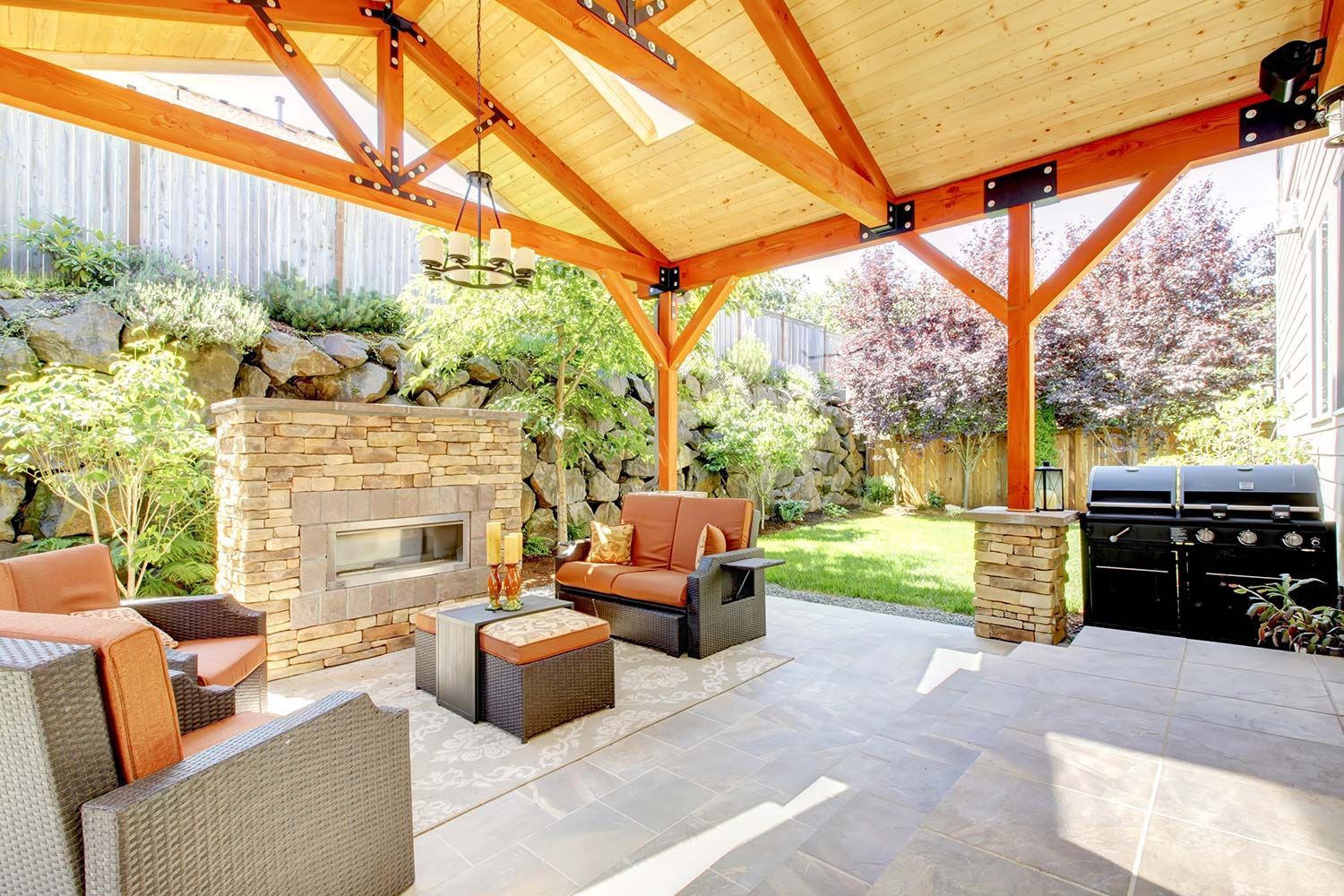Covered outdoor patio with stone fireplace