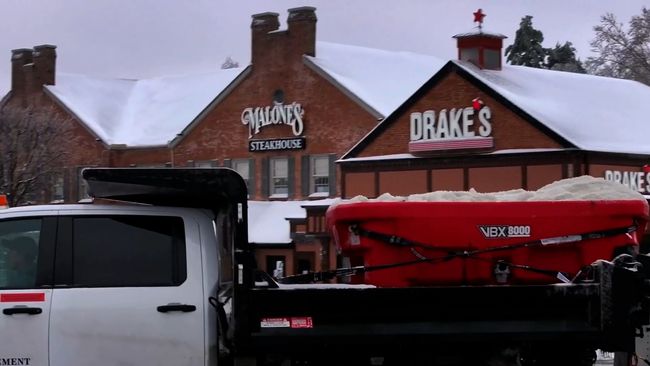Man mowing a lawn near a church on a sunny day.