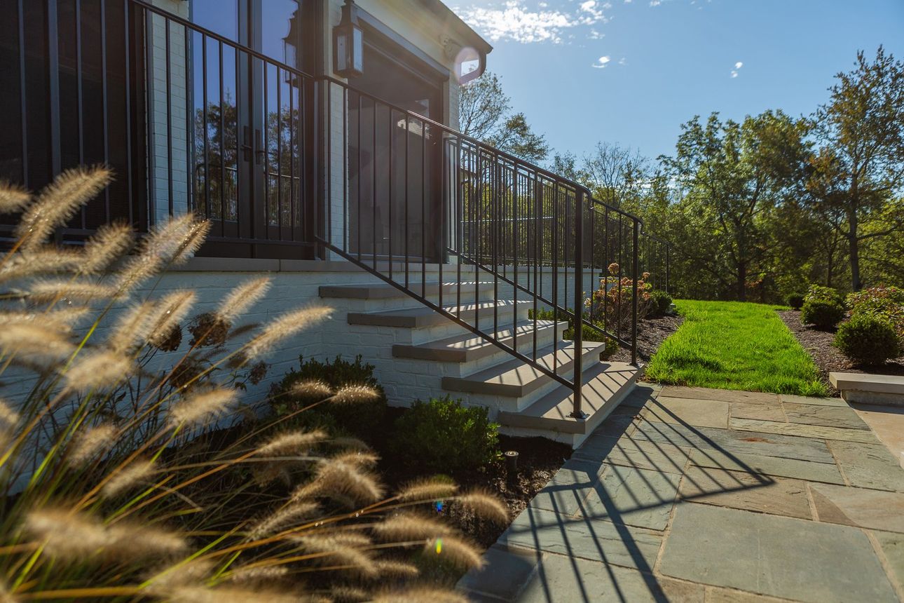 Green park with trees, basketball court, and people on a sunny day.