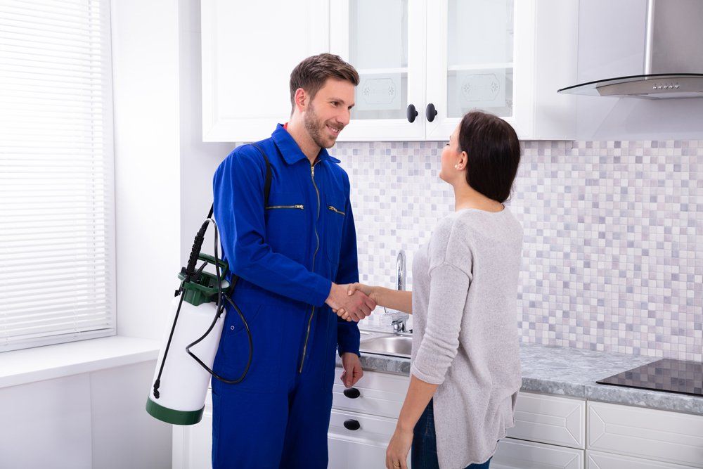 Pest Control Worker Shaking Hands With Woman — Westchester, PA — Regal Pest Management