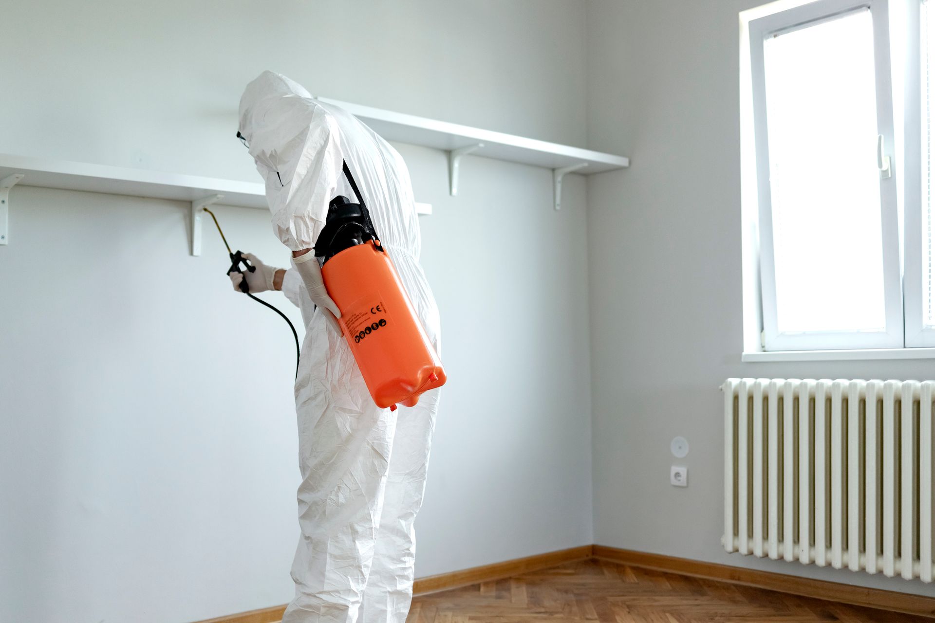 A man is spraying a house for termite treatment.