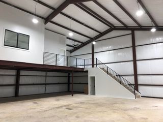 A large empty building with stairs leading up to the second floor.