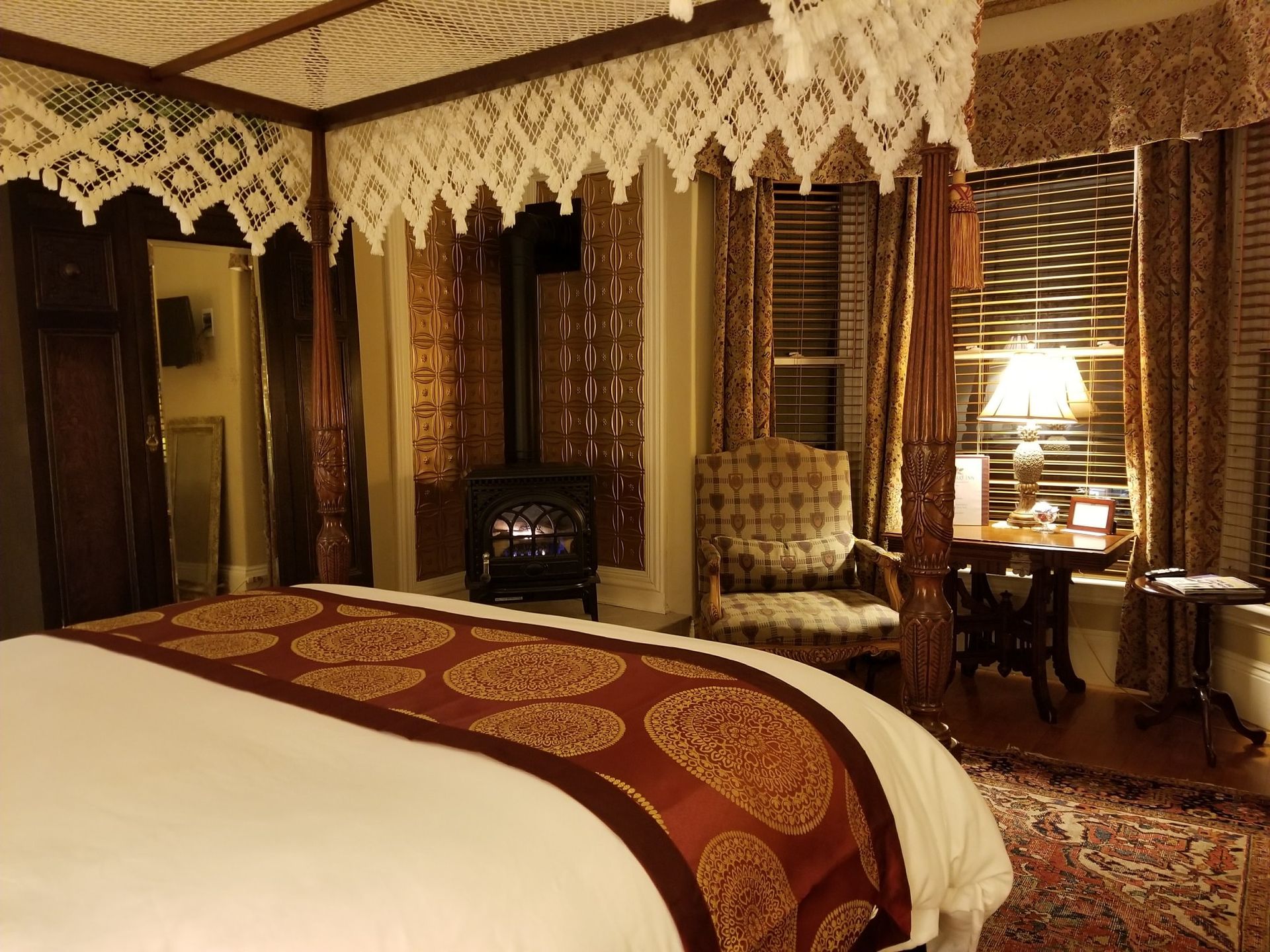 A bedroom with a canopy bed and a chair