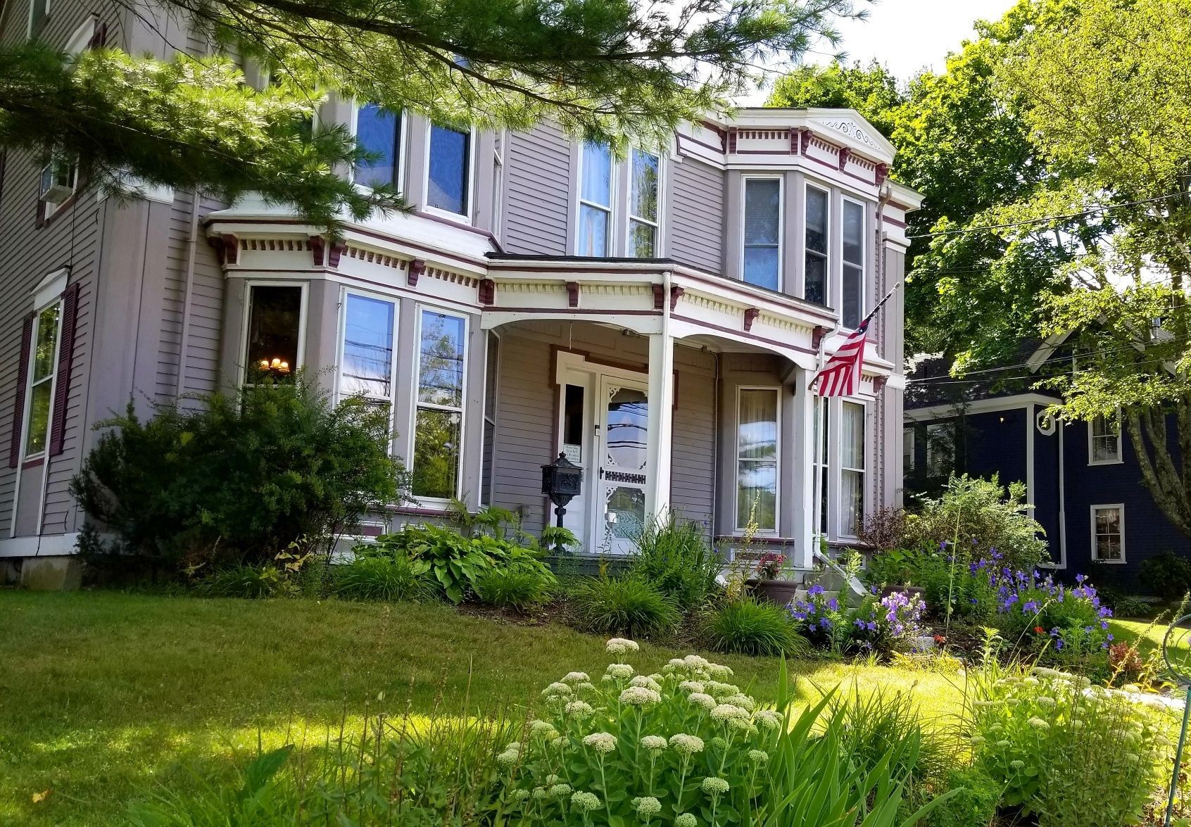 A large house with a porch and a flag on it