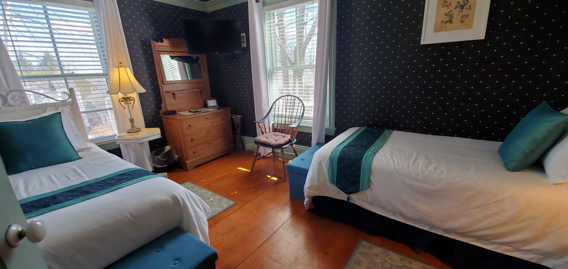 A bedroom with two beds , a chair and a window.