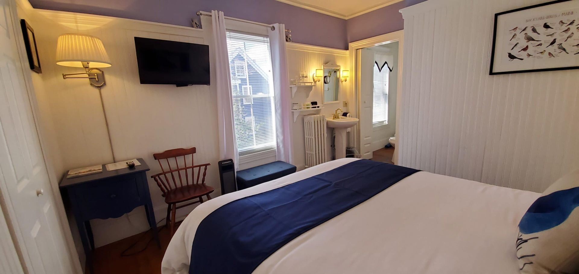 A bedroom with a bed , chair , table and television.
