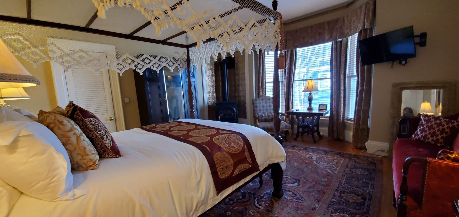 A bedroom with a canopy bed and a couch.