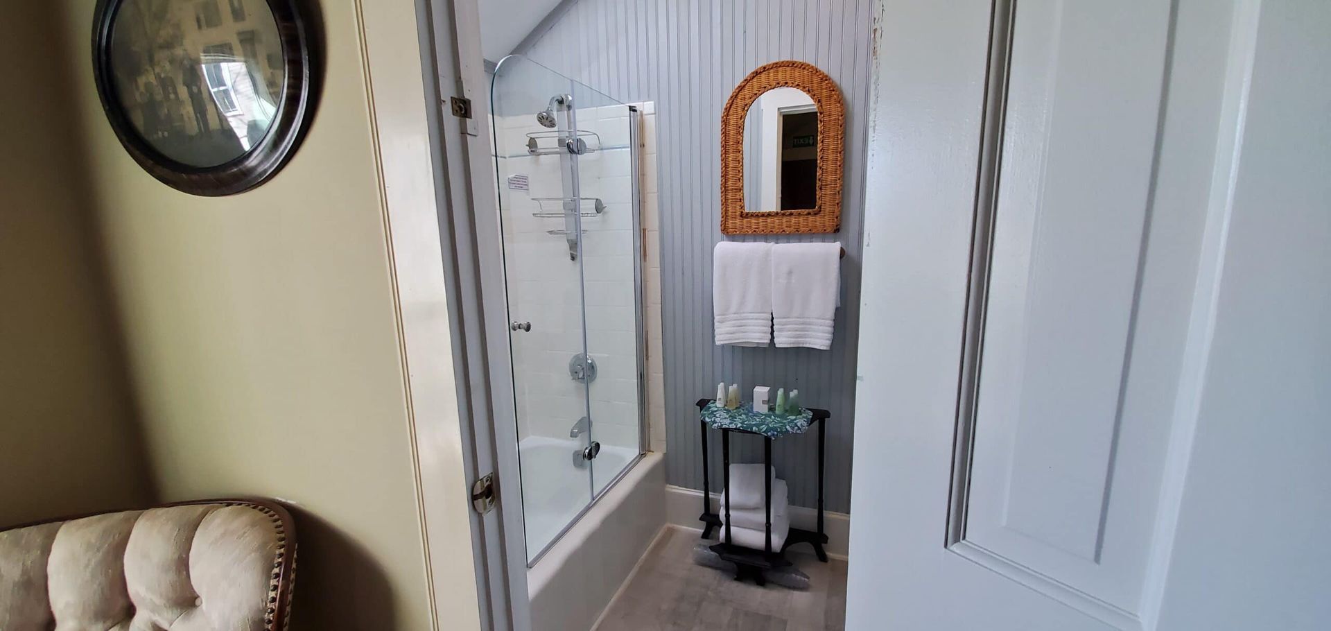 A bathroom with a tub , shower , sink and mirror.