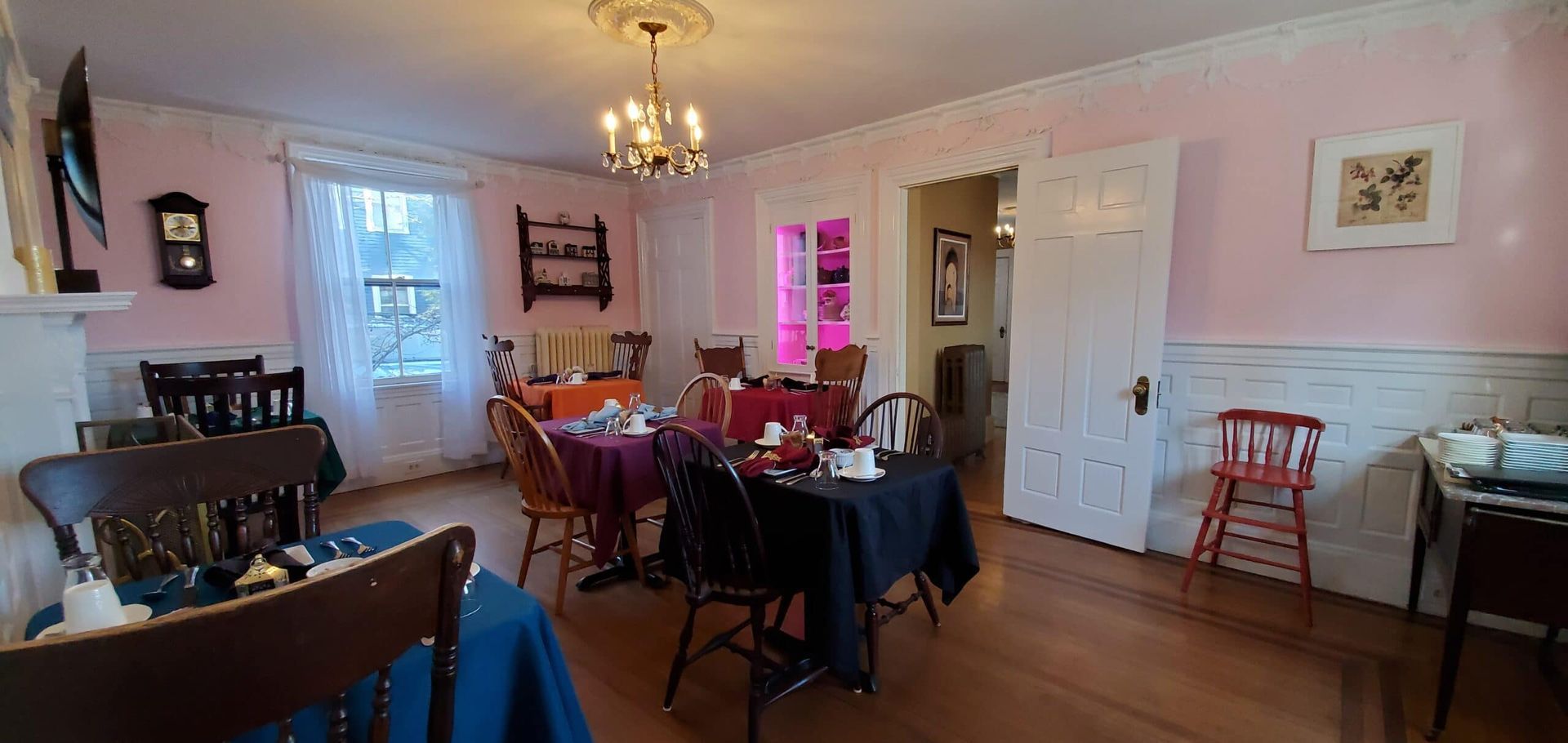 A dining room with tables and chairs and a fireplace.