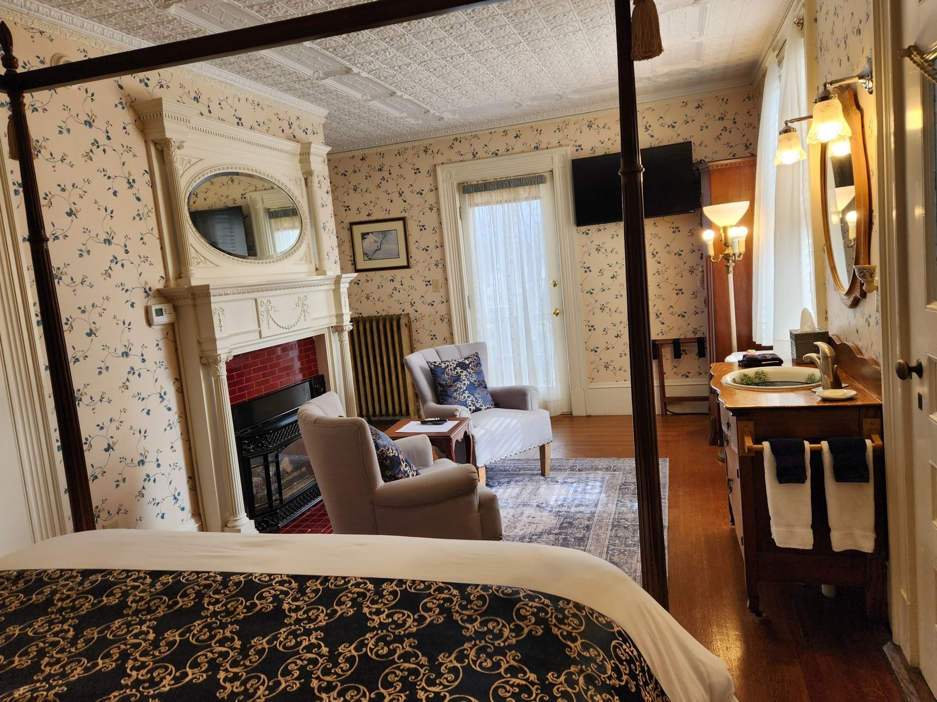 A bedroom with a four poster bed and a fireplace