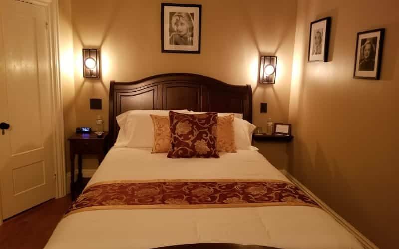 A bedroom with a bed and two pictures on the wall