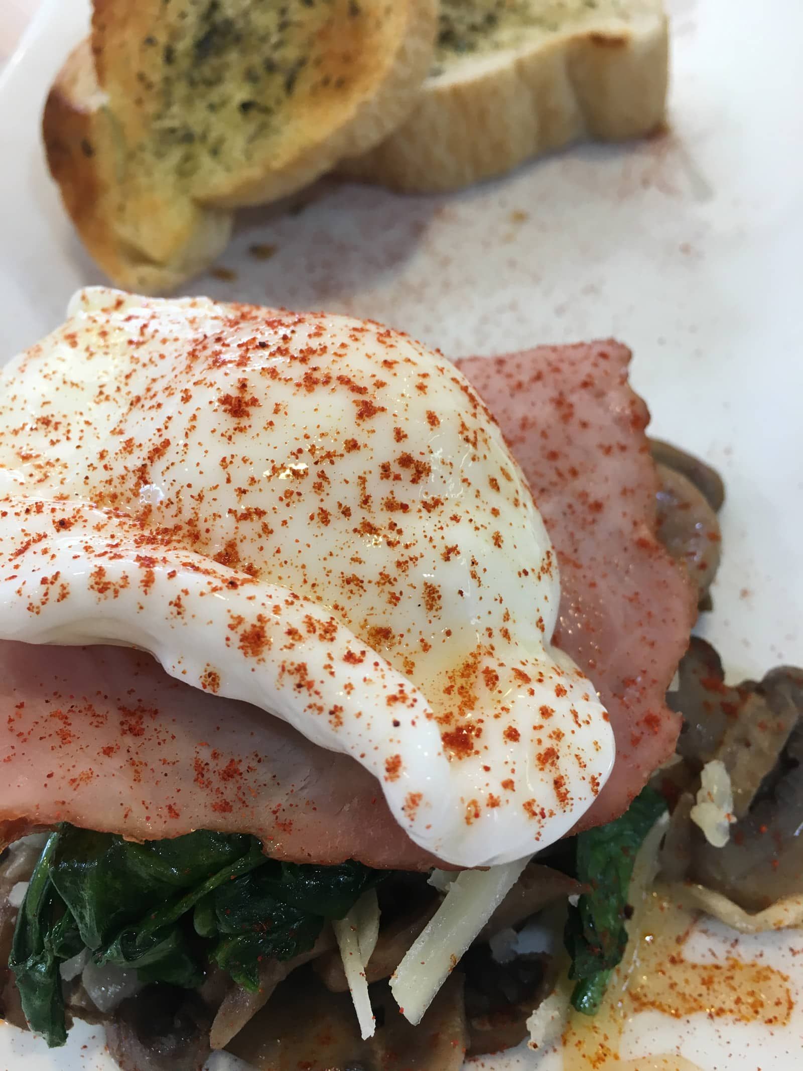 A close up of a plate of food with a poached egg on top