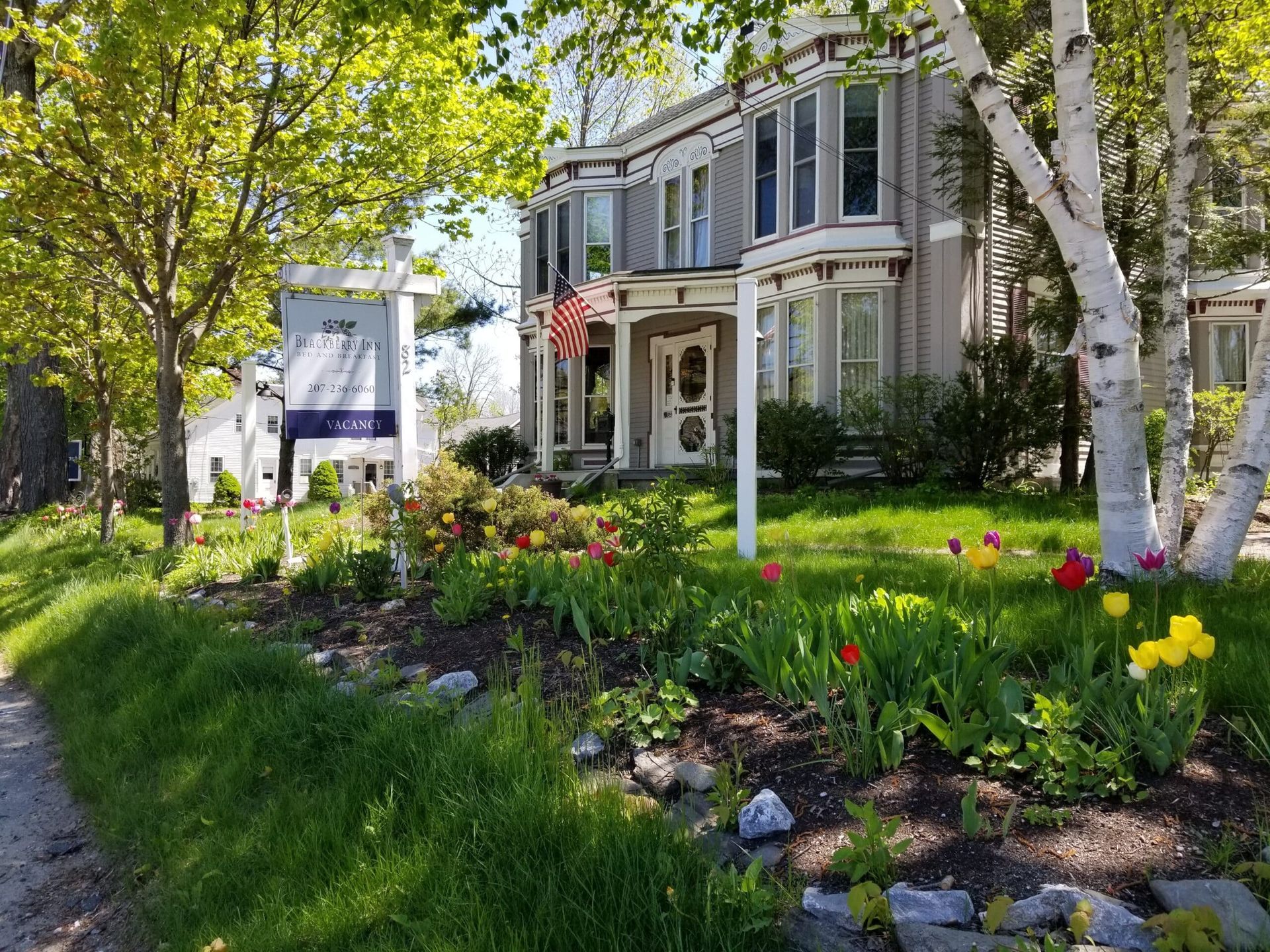 A large house with a lot of flowers in front of it.