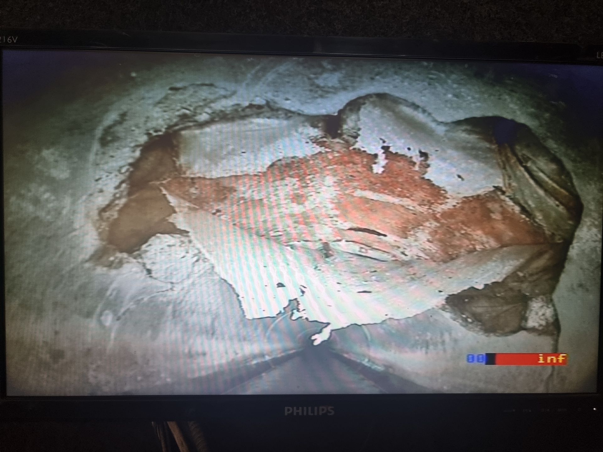 Inside a pipe: orange/brown interior, surrounded by white and gray, viewed from below — Pro Pipe Solutions in Queanbeyan, NSW